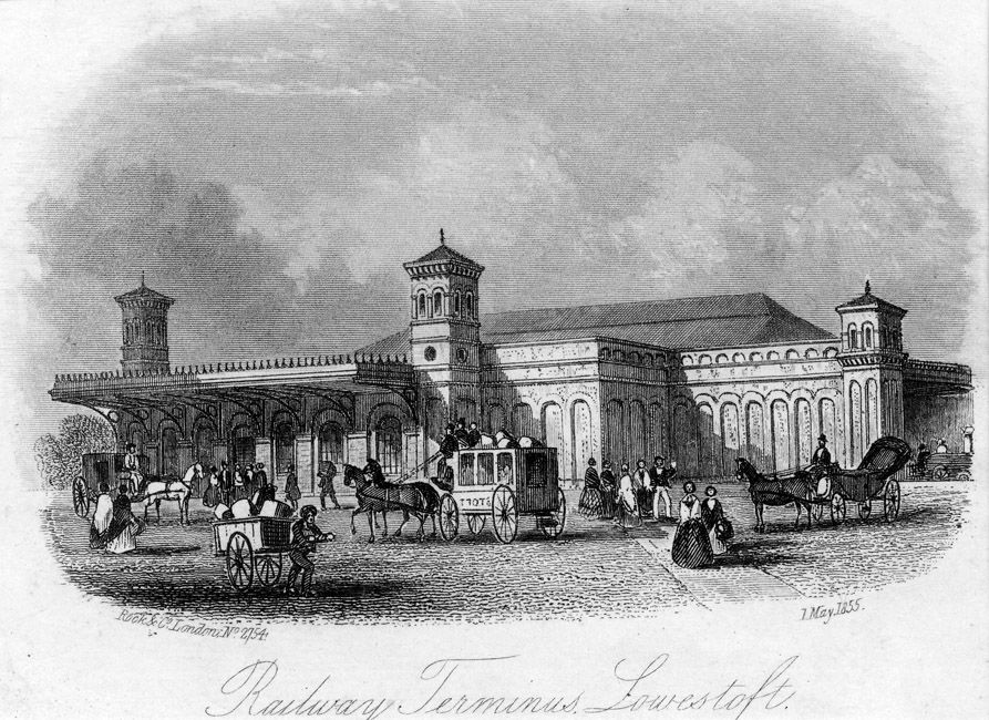 A drawing of Lowestoft Transport Railway Station created on the 7th of May 1855.  The building has three raised towers – one on the right, one just of centre at the front of the building, and one on the far-left hand side of the building. There are multiple arches present on the walls of the building, although they appear to be there for decorative purposes only. They go up to about two thirds of the height of the building (not counting the roof and towers). To the left-hand side of the building, at the front, there are multiple arched shaped windows which are placed in the middle of the building, height wise. Above the arched windows is an awning which stretches quite far out.  Whilst there is a roof covering the entirety of the building, from the front to the centre, the roof is flat but from the centre to the back, the roof is diagonally raised (like on most house roofs).  Outside the station, there are many people congregated in front of the building going in most directions. There are also horse and carts, some with people on, some waiting for people to get on at the station as well as people pulling carts with cargo loaded on. To the right-hand side of the sketch is a path which leads to the station front.